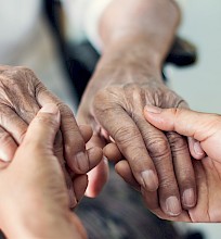 Pflegerin von Spitex Zämespanne hält Hände von Seniorin