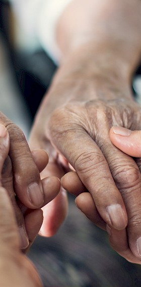 Pflegeperson von Spitex Zämespanne hält die Hände einer Seniorin